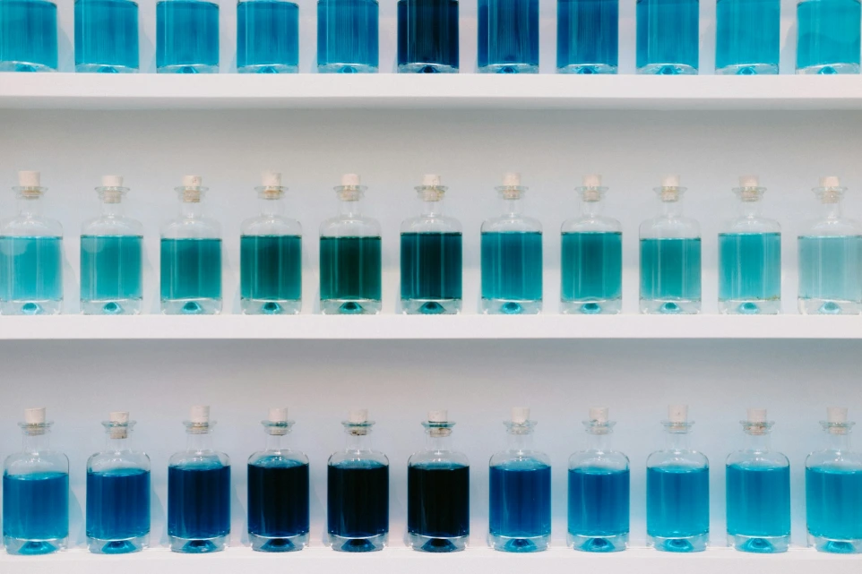 a group of blue bottles on a white shelf huasun